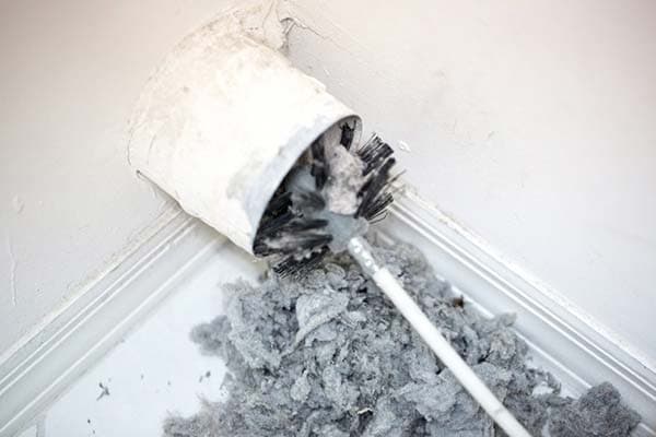 Duct cleaning brush removing dust and debris from a vent